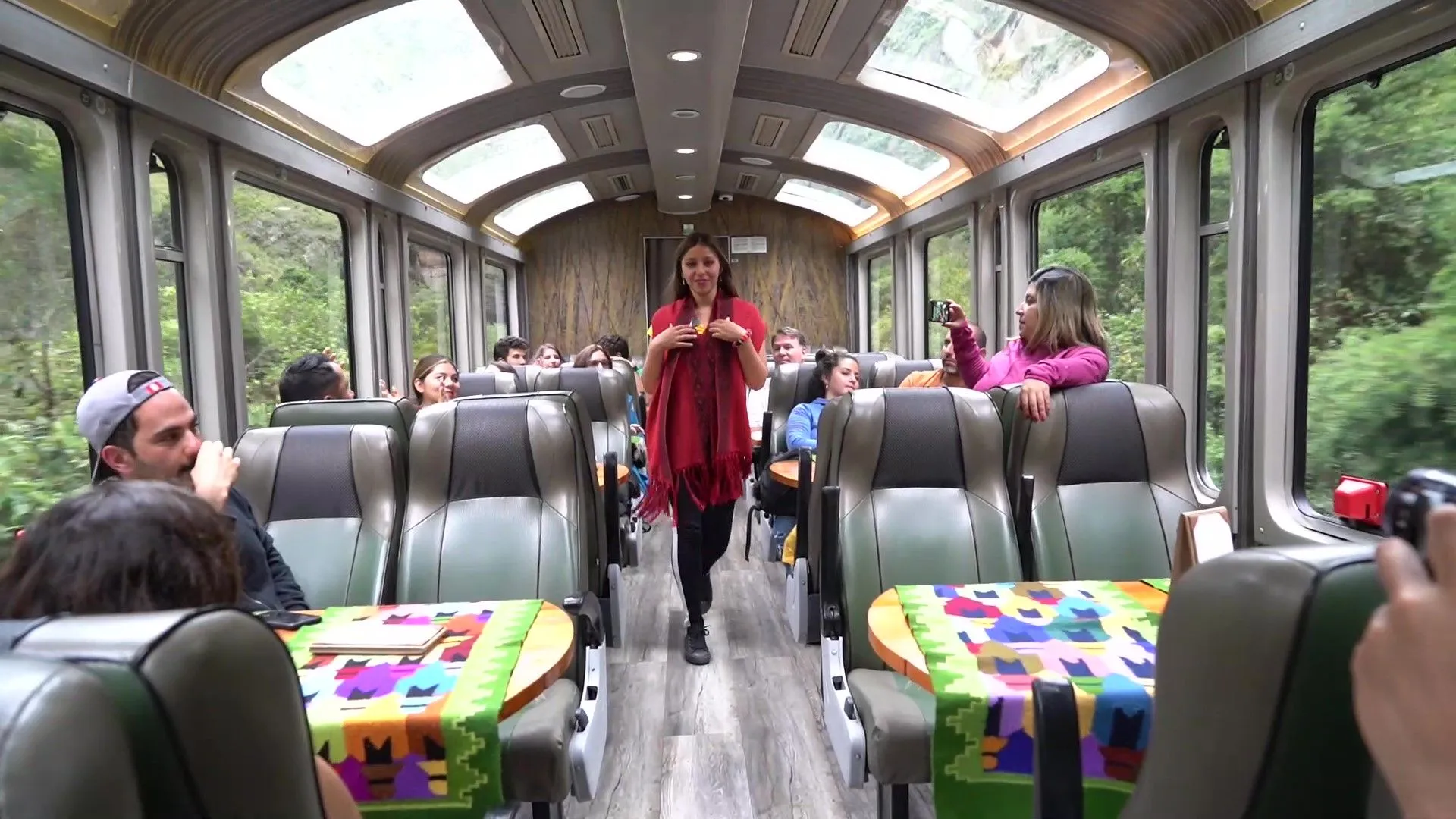 Passengers enjoy scenic train ride with large windows.