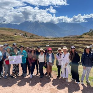 Group posing in front of scenic mountain landscape.