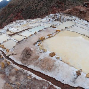 Salt evaporation ponds in rugged mountainous landscape.